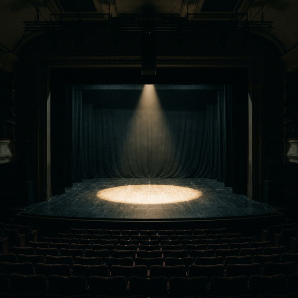 Empty theater stage with spotlight on wooden floor and closed curtains